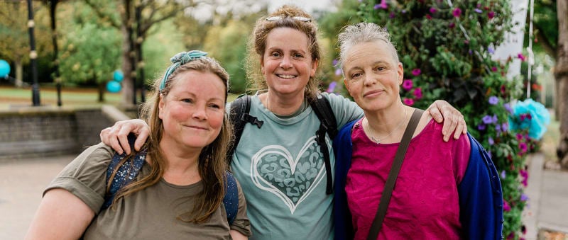 Three people standing together at an ovarian cancer group event
