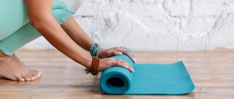 Person unrolling a yoga mat