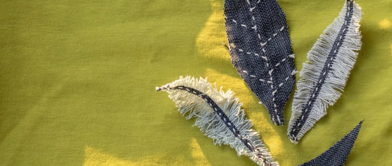 Fabric leaves on yellow linen background