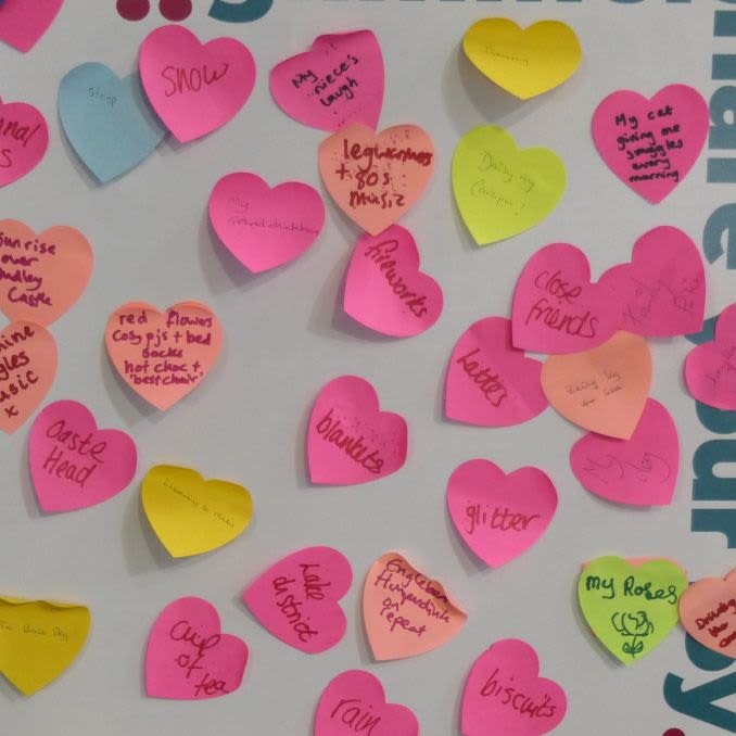 A board covered in heart-shaped post it notes with the group